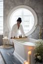 Black woman preparing for spa treatment in bathroom