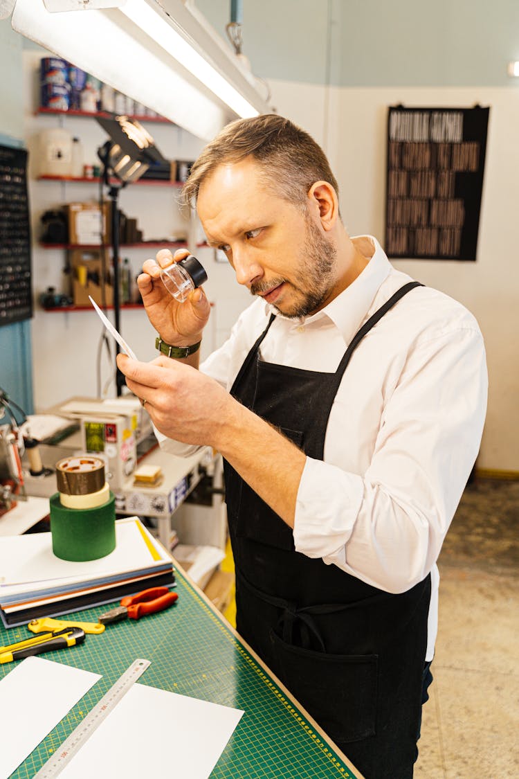 Man Working With Printing Tools Using Magnifier