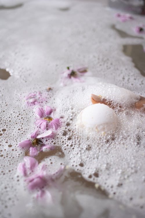 Free White ball of bath salt on water surface with foam Stock Photo