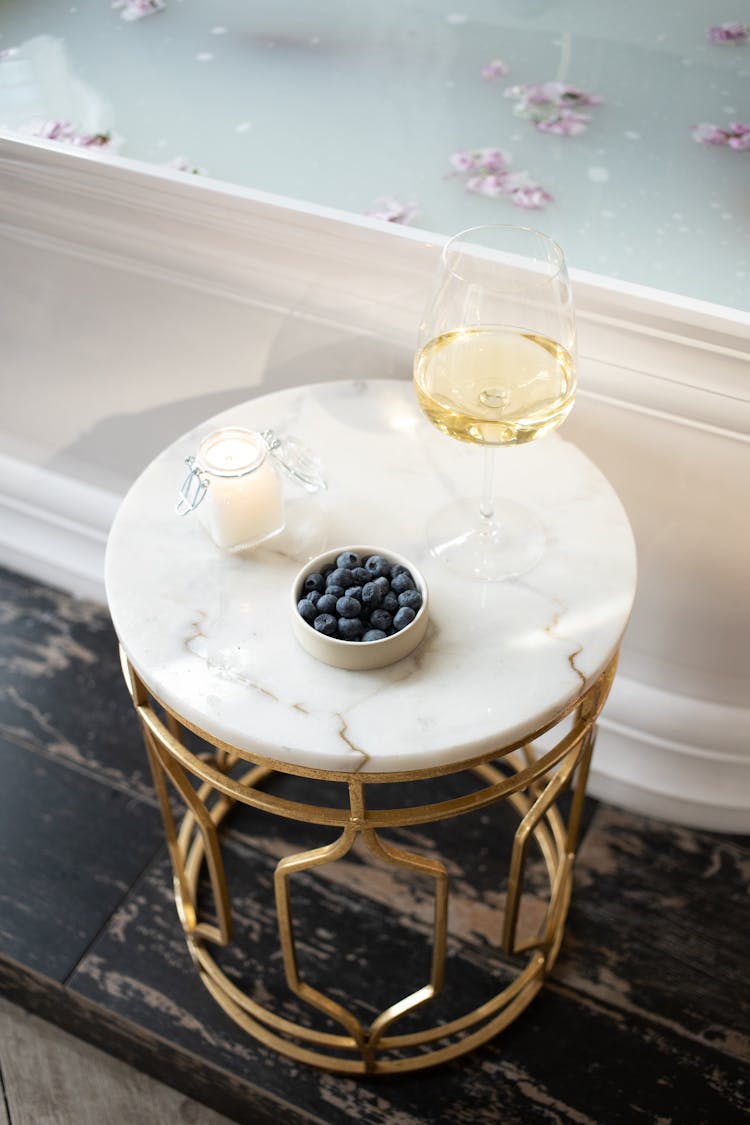 Glass Of Wine And Candle On Round Table Near Tub