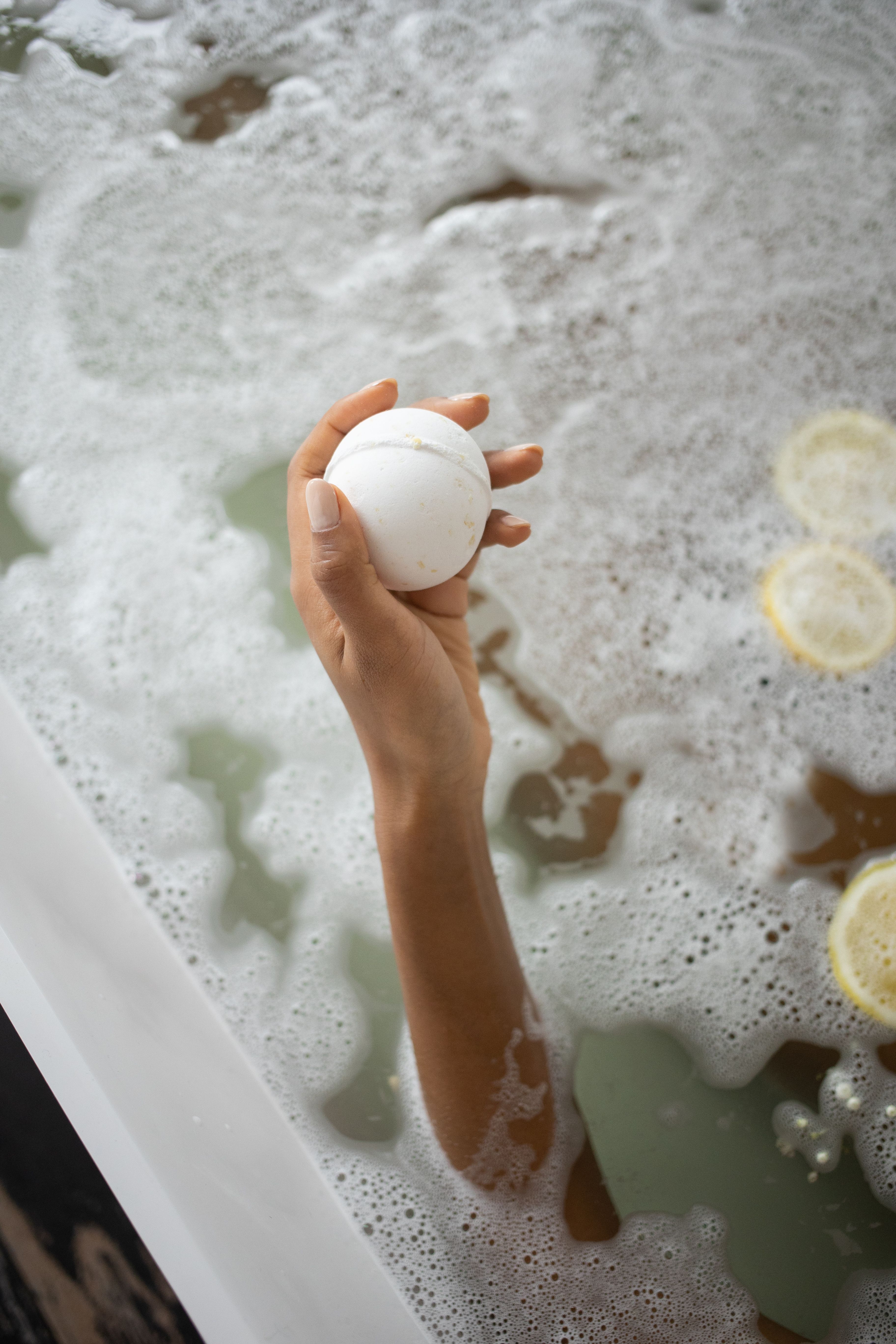 White ball of bath salt on water surface with foam · Free Stock Photo