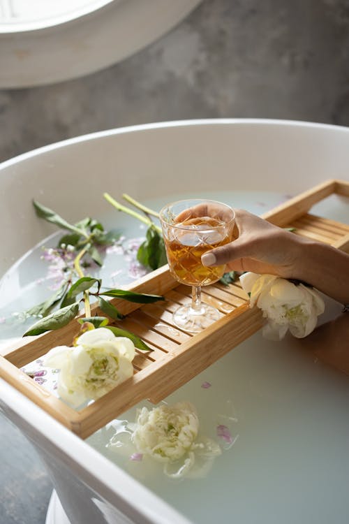 Free Woman with wineglass and flowers in bathtub Stock Photo