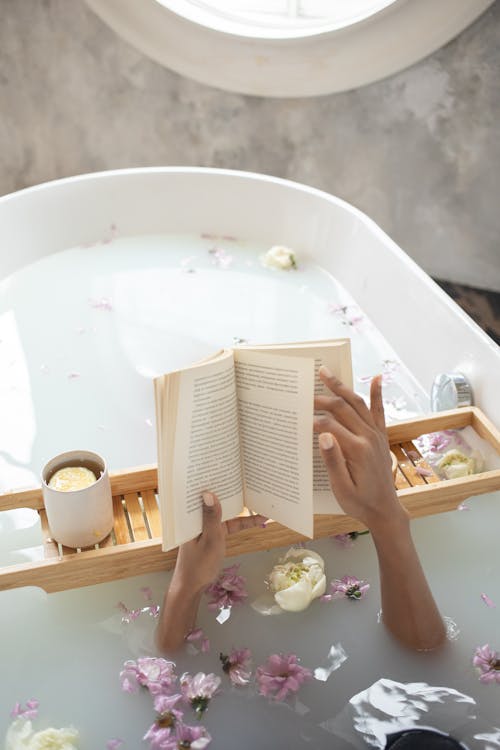 Free Woman with book and cup of coffee in bath Stock Photo