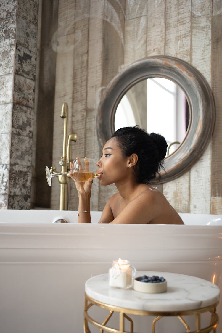 Ethnic Woman Drinking White Wine In Bathtub