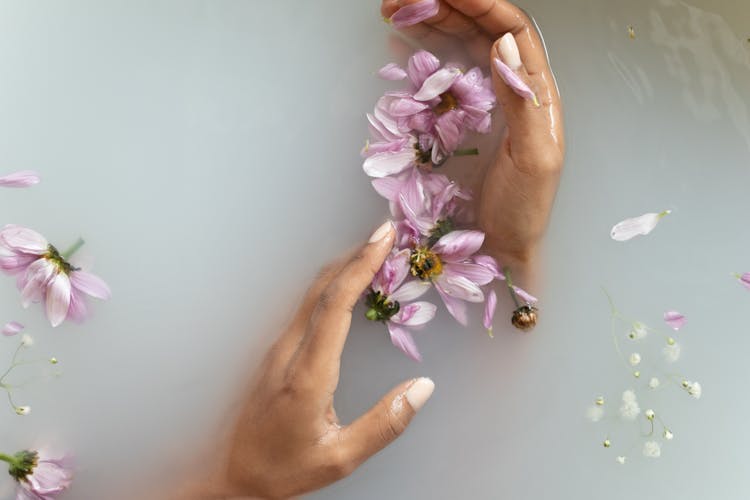 Woman Holding Flowers In Hands In Water