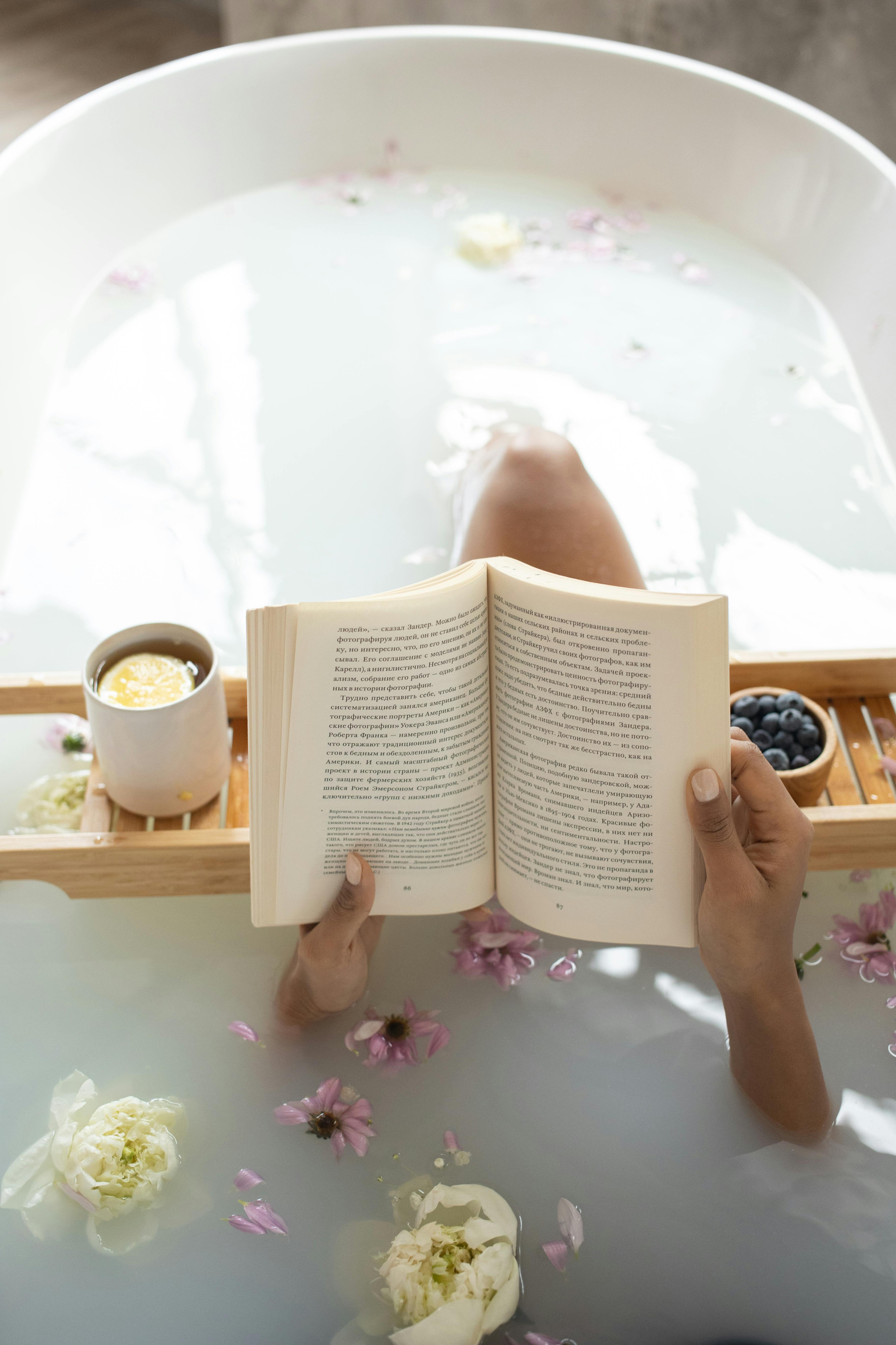 woman reading book in bathtub during spa procedures