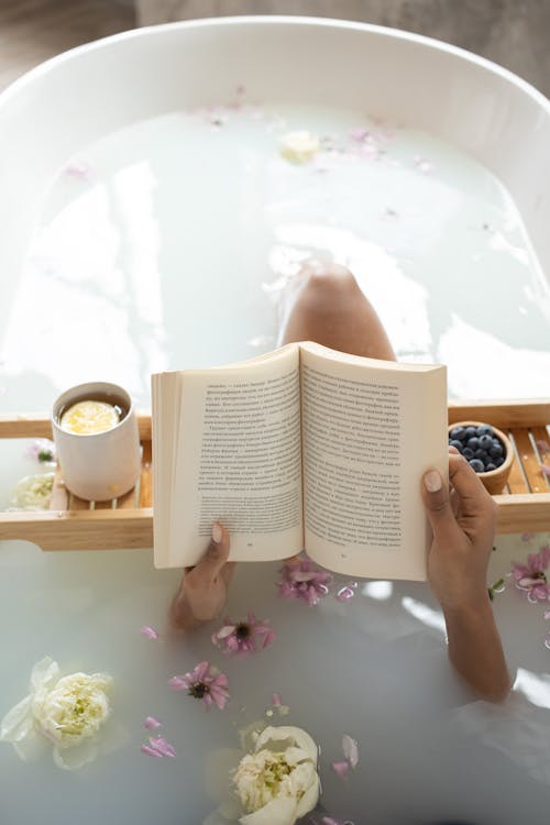 Woman reading book in bathtub during spa procedures