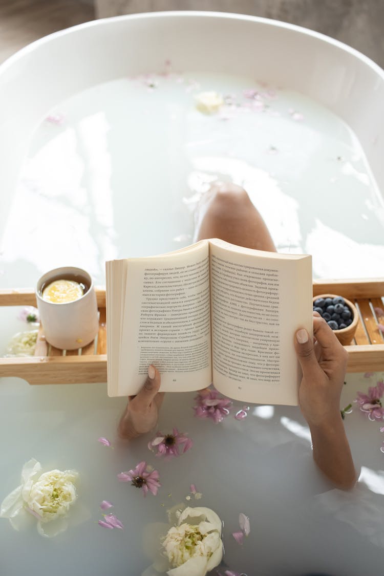 Woman Reading Book In Bathtub During Spa Procedures