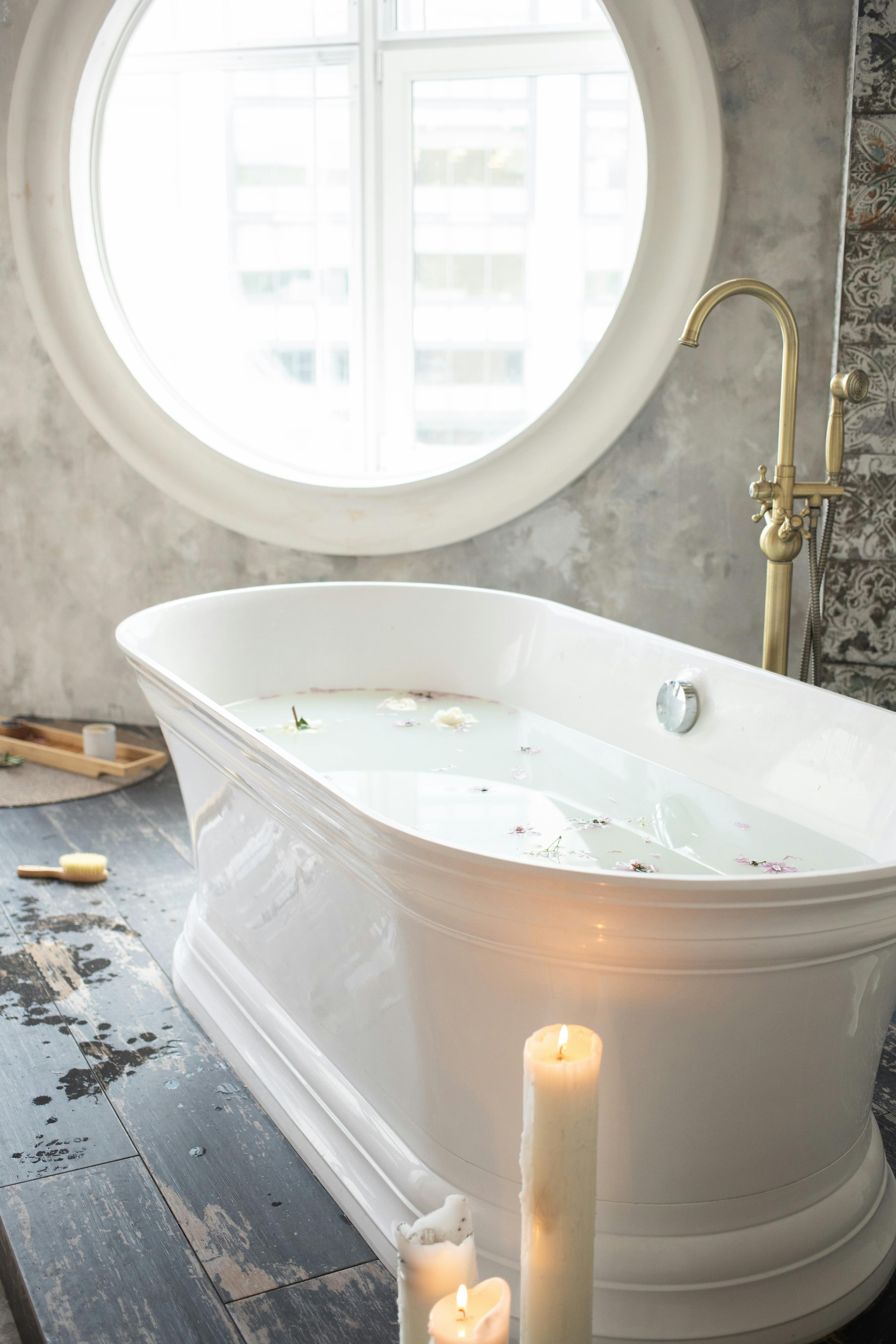 bathroom with white water in bath and flower petals