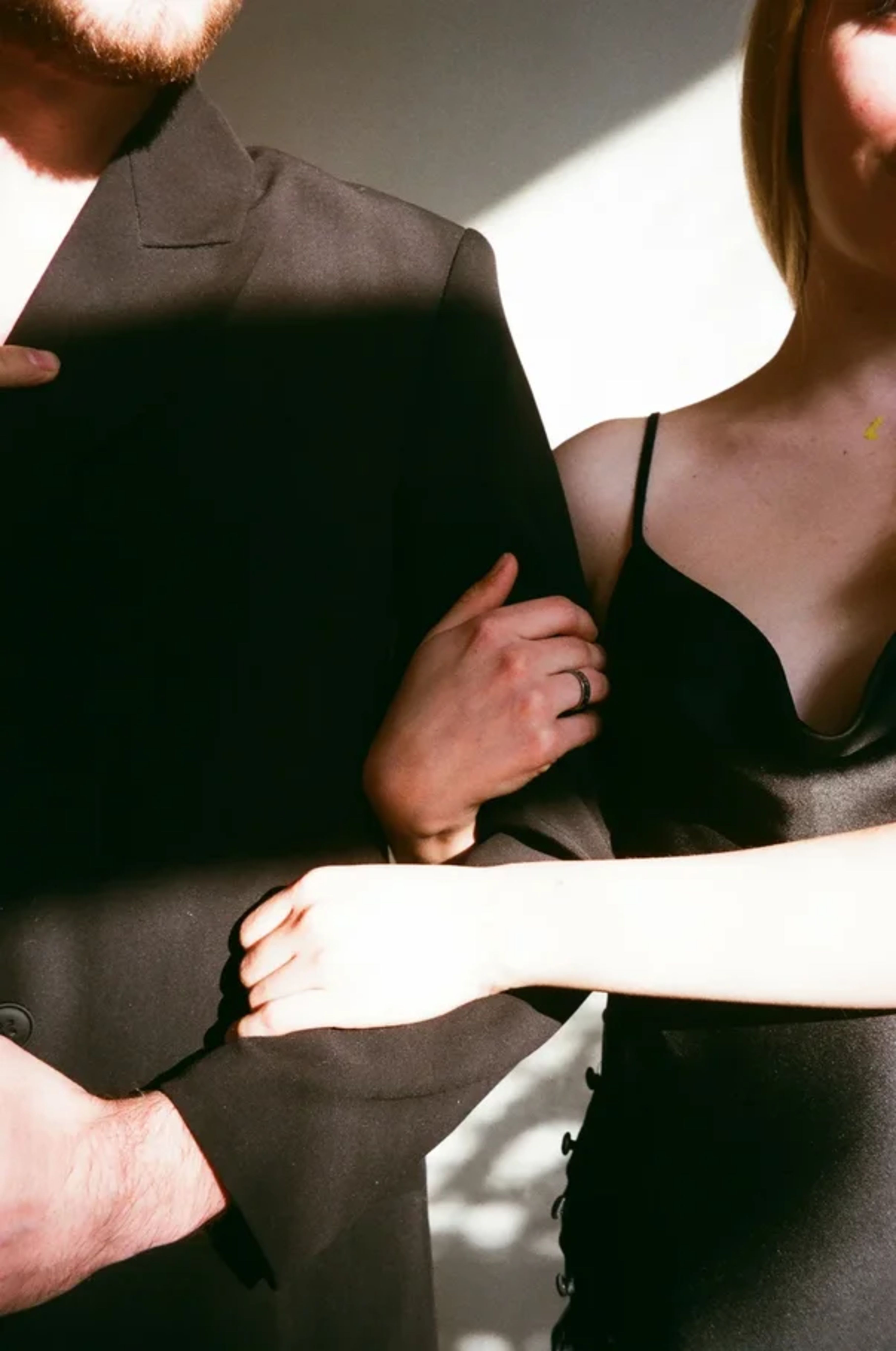 A couple in elegant attire holding hands, symbolizing intimacy and connection.