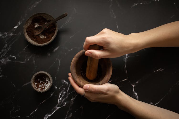 Woman Grinding Coffee In Mortar