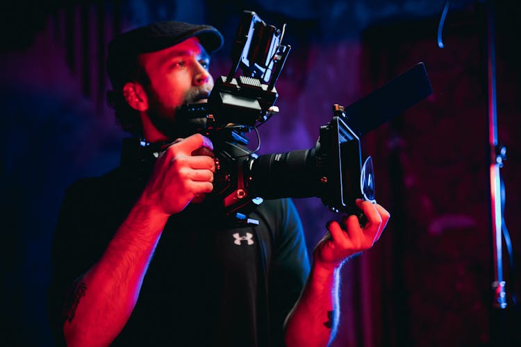 Photo Of A Man With A Flat Cap Using A Camera