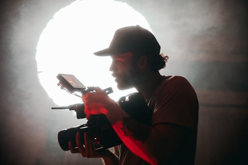 Photo of a Videographer Surrounded by Smoke