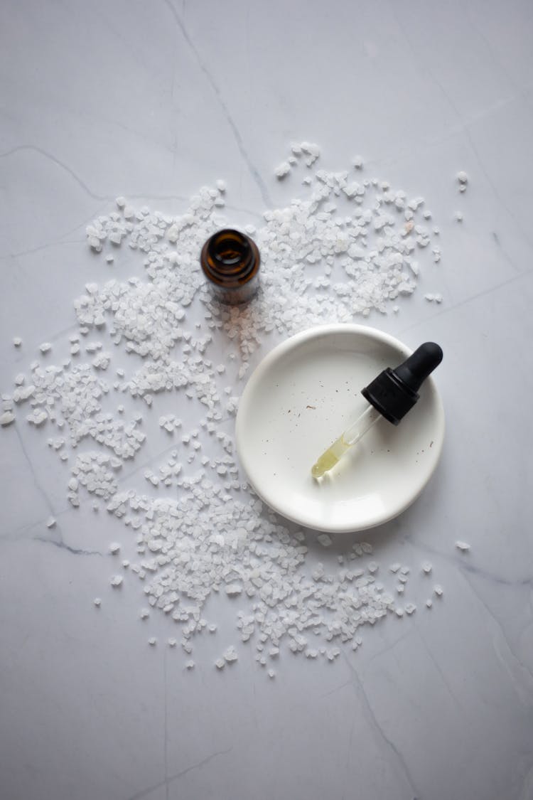 Cosmetic Product With Oil Placed On Plate On Marble Table