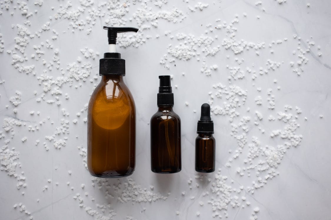 Bottles of cosmetic products placed on white surface