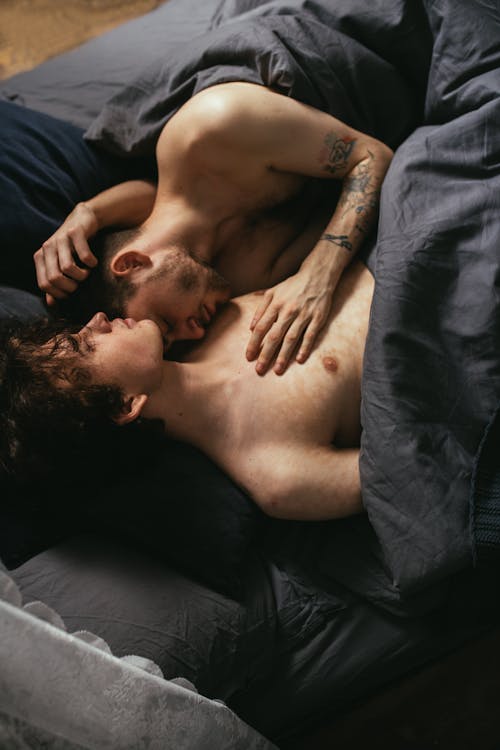 Free Shirtless Men Lying on Bed Stock Photo