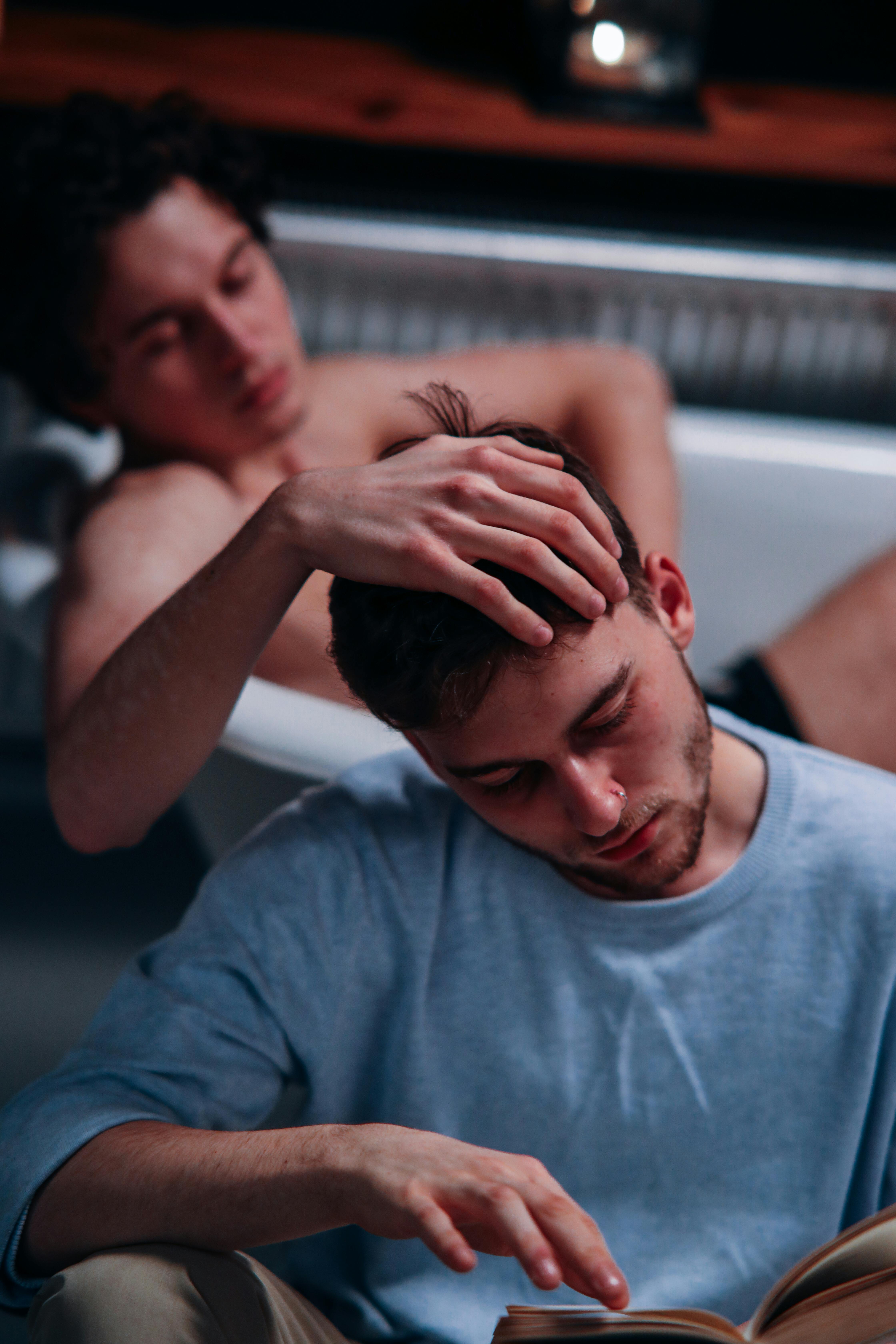 photo of a man in a bathtub touching a man s head
