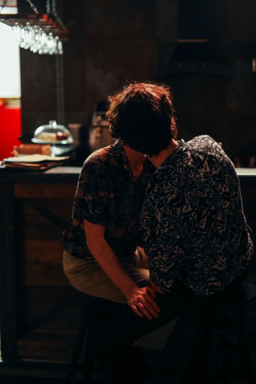 Free A couple shares an intimate moment in a dimly lit bar setting, emphasizing warmth and connection. Stock Photo