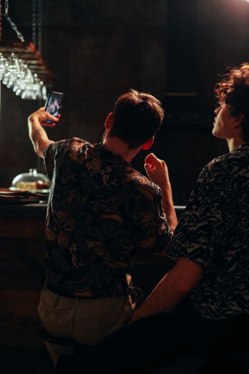 Free A young couple enjoys a night out, capturing a selfie at a dimly lit bar. Stock Photo
