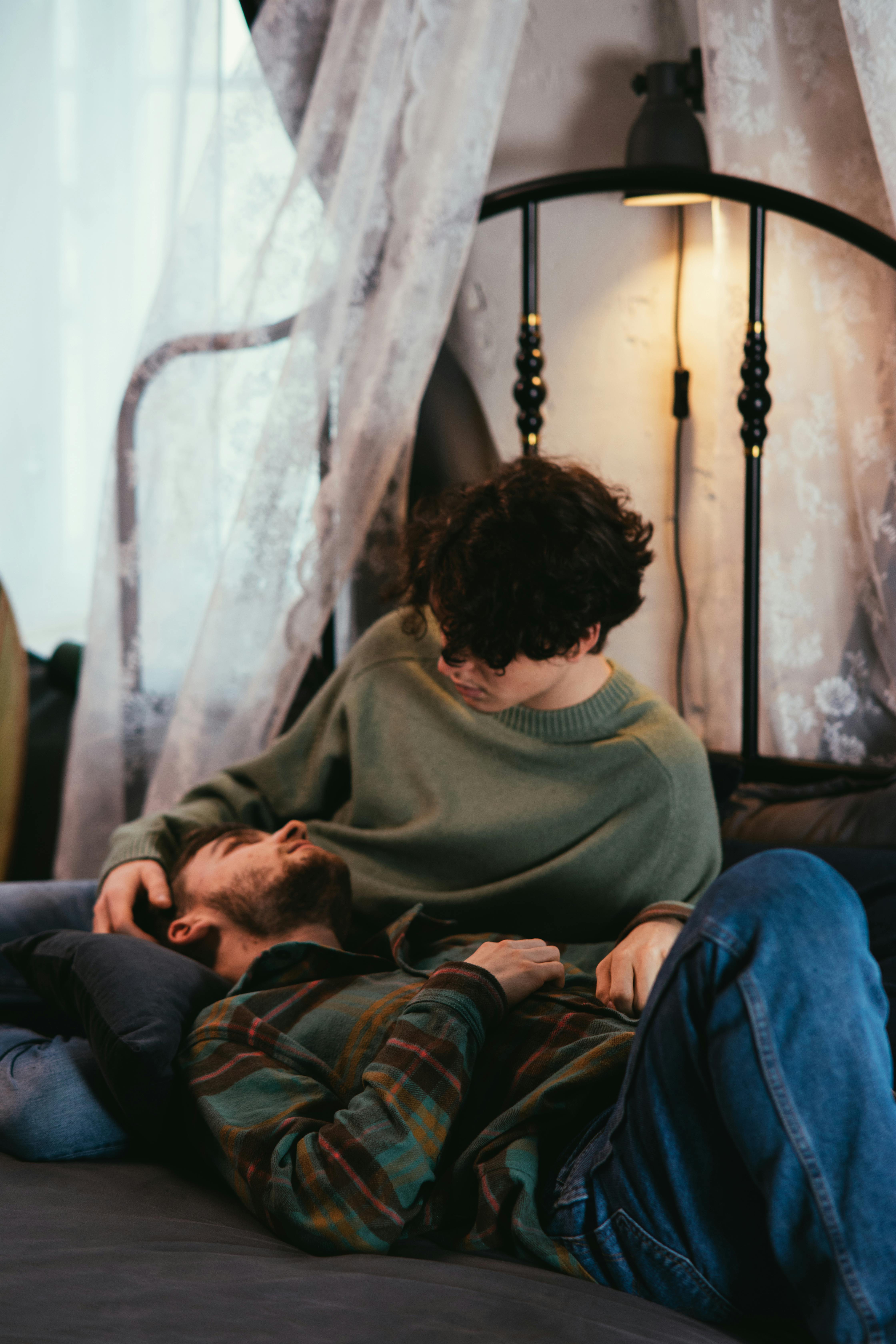 a couple looking at each other while on the bed