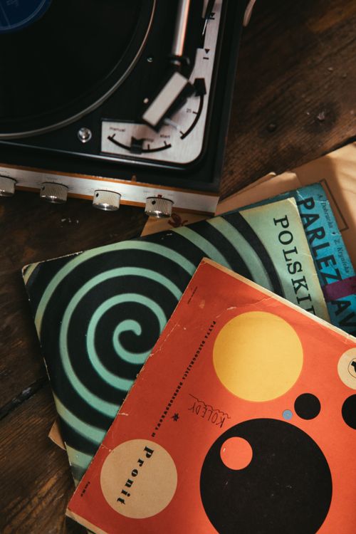 Stacked vinyl records beside a vinyl player, overhead view