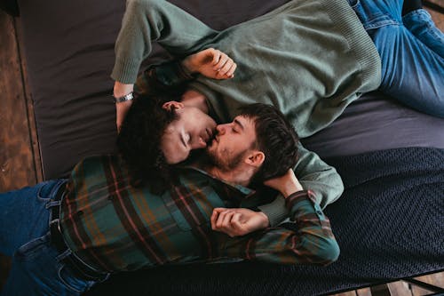 Men Lying on Bed While Facing Each Other