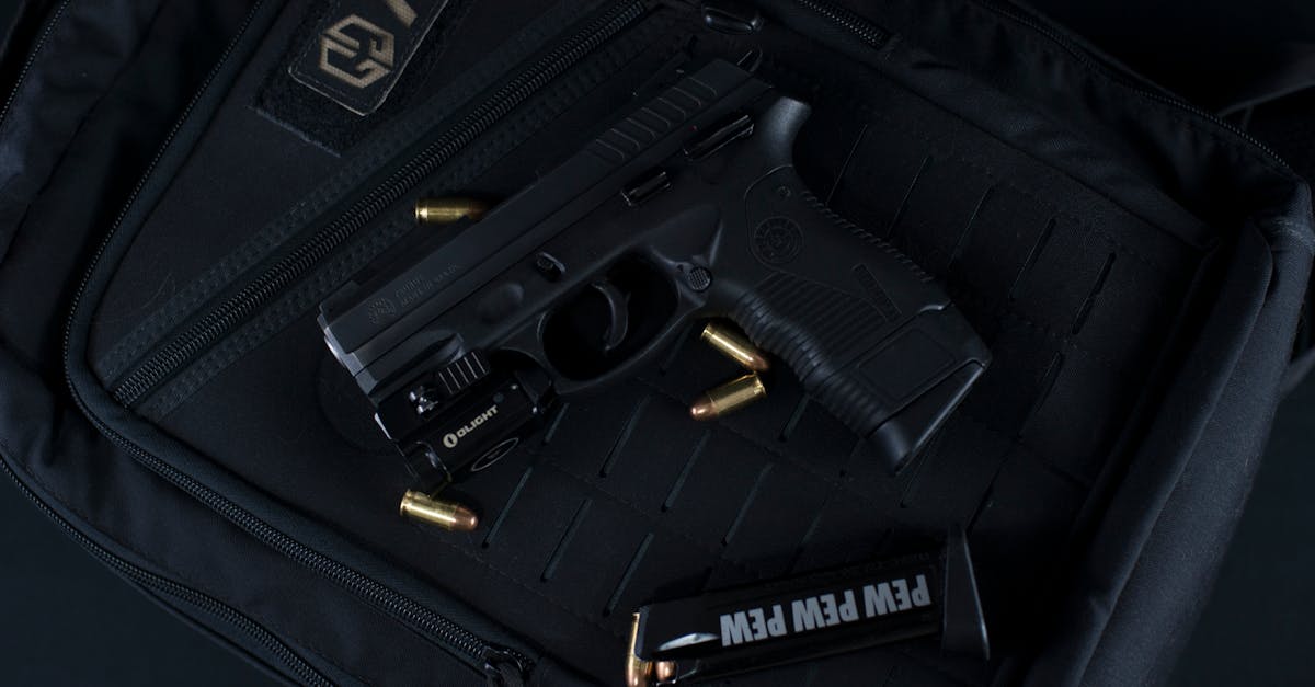 Photo by Dan Galvani Sommavilla A black handgun and bullets on a tactical backpack, ideal for security and defense concepts.