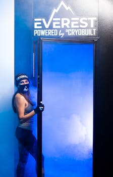 A woman prepares for a cryotherapy session indoors, showcasing modern fitness and health technology.