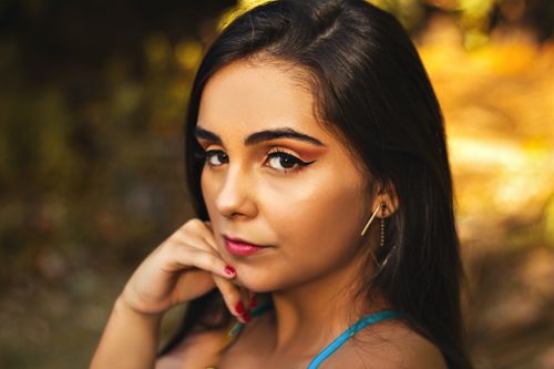 Free Close-up portrait of an adult woman with makeup, serene expression, and a blurred background. Stock Photo