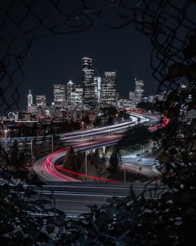 A stunning view of Seattle's skyline at night, capturing dynamic light trails from traffic.