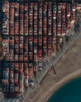 Stunning aerial capture of Barcelona showing neatly arranged urban grid alongside the beach, perfect for travel and architecture themes.