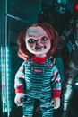Doll with terrible face in overalls at home