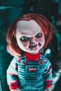 Creative design of doll with redhead and freckles on terrible face representing aggressive character at home