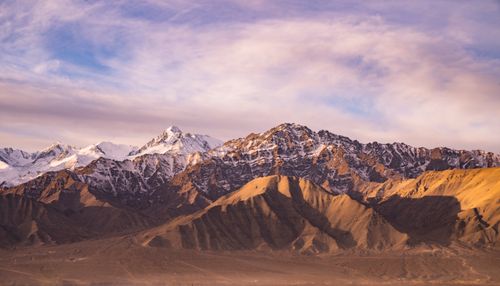 Free Stunning view of snow-covered rocky mountains during sunset, capturing nature's beauty. Stock Photo