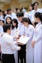 Group of People in White Uniform Holding White Printer Paper