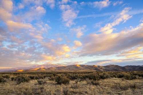 Free Spectacular landscape of dry grassy meadow near hills under cloudy blue sunset sky in countryside Stock Photo
