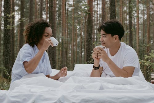 Shallow Focus of Romantic Couple Drinking Coffee on Bed