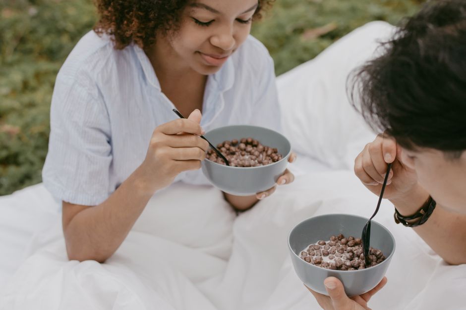 Bol de cereales de desayuno con chocolate sobre mesa blanca, visto desde arriba