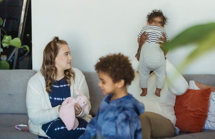 Anonymous Diverse Family Interacting On Sofa At Home