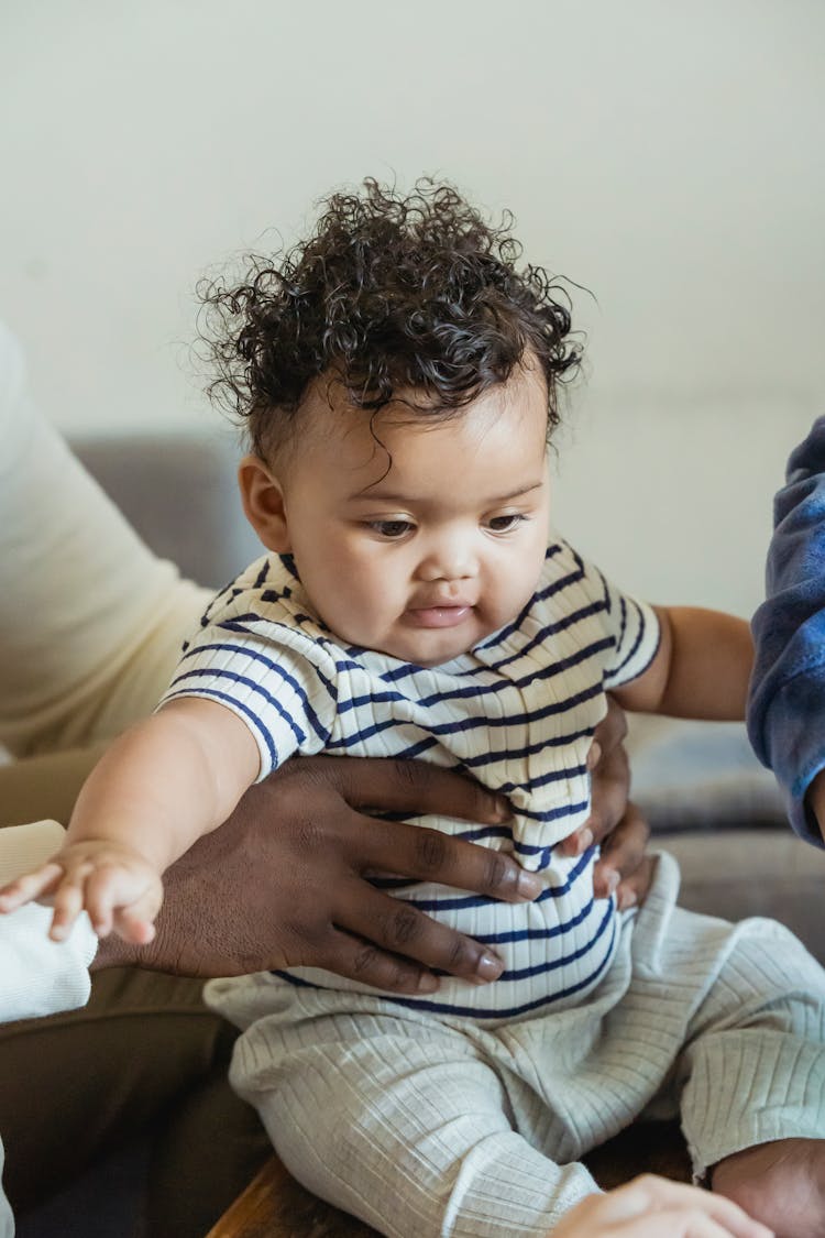 Faceless Ethnic Parent With Cute Baby At Home