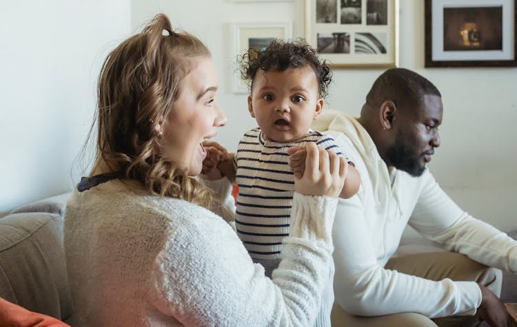 Mom Playing With Cute Baby Near Black Father