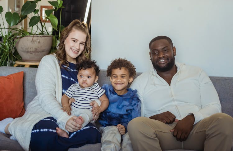 Happy Diverse Family Sitting Close On Sofa