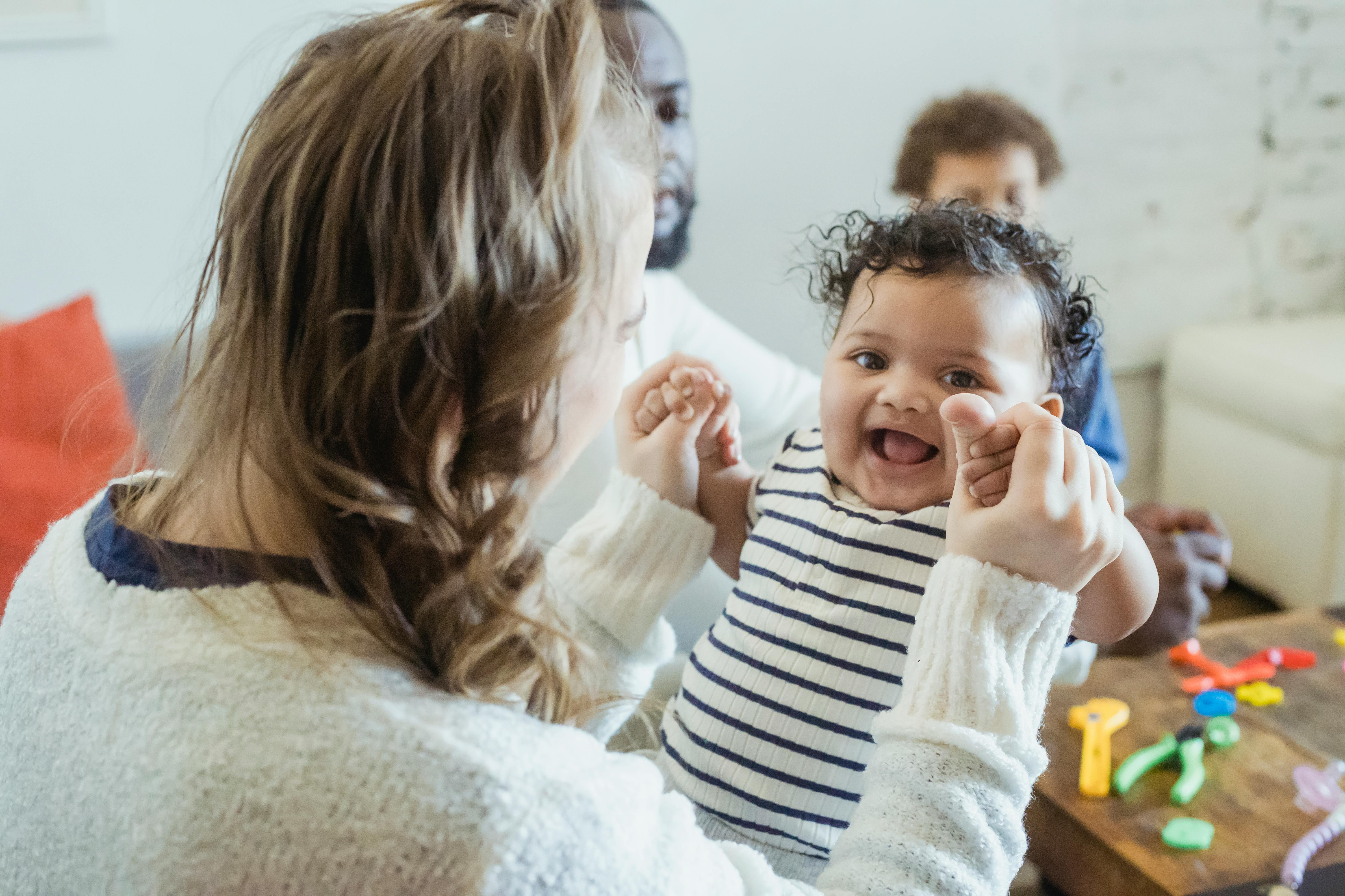 mother playing with cute black baby