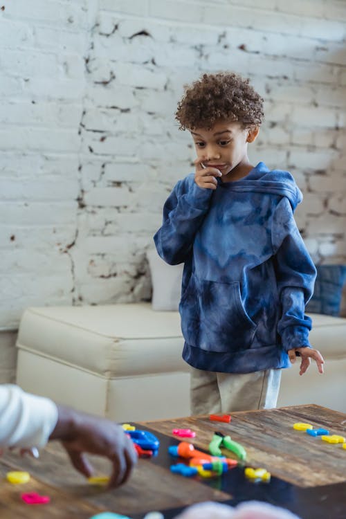 Amazed black boy standing at table with toys