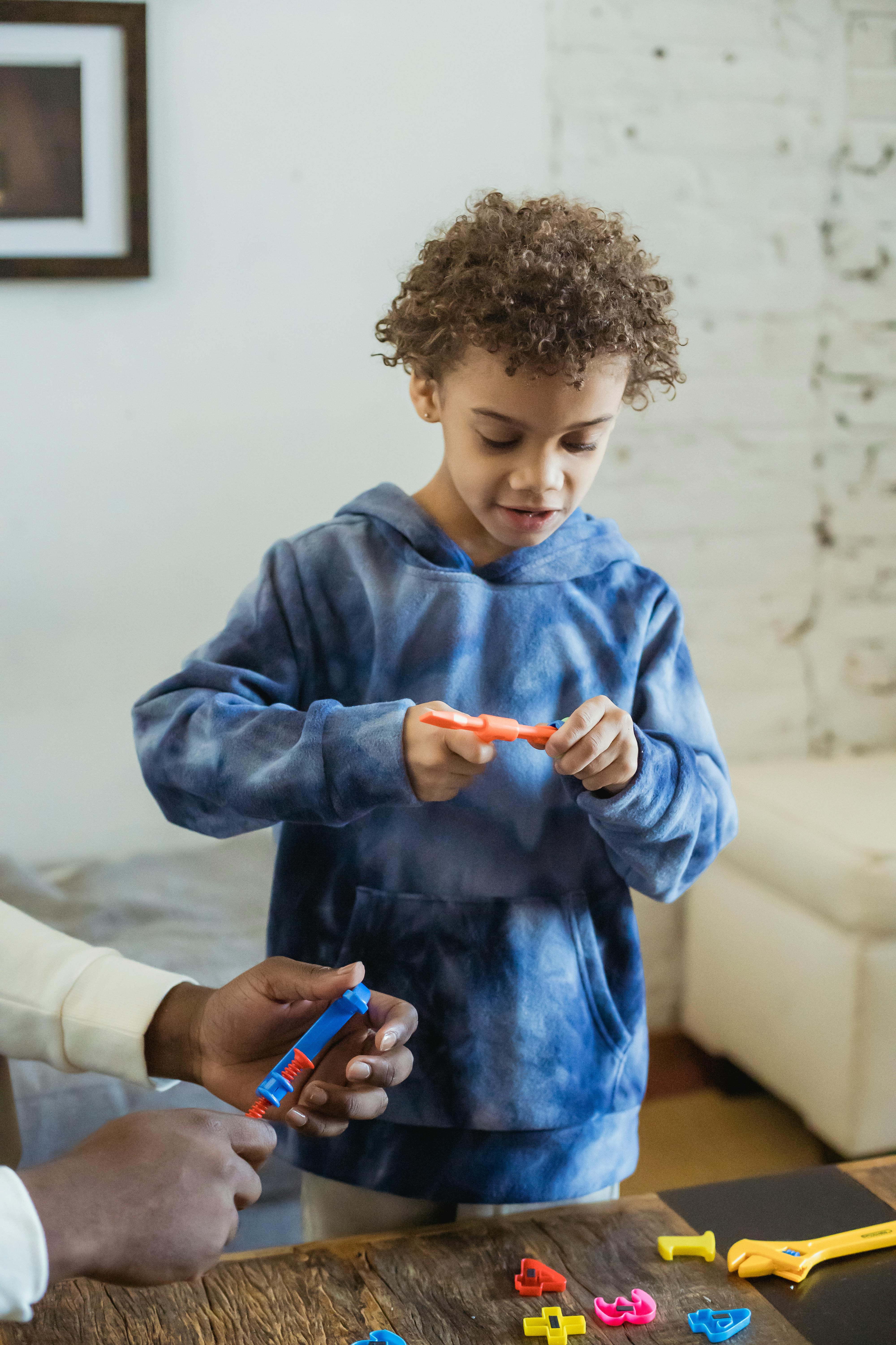 curious black boy playing toys with father