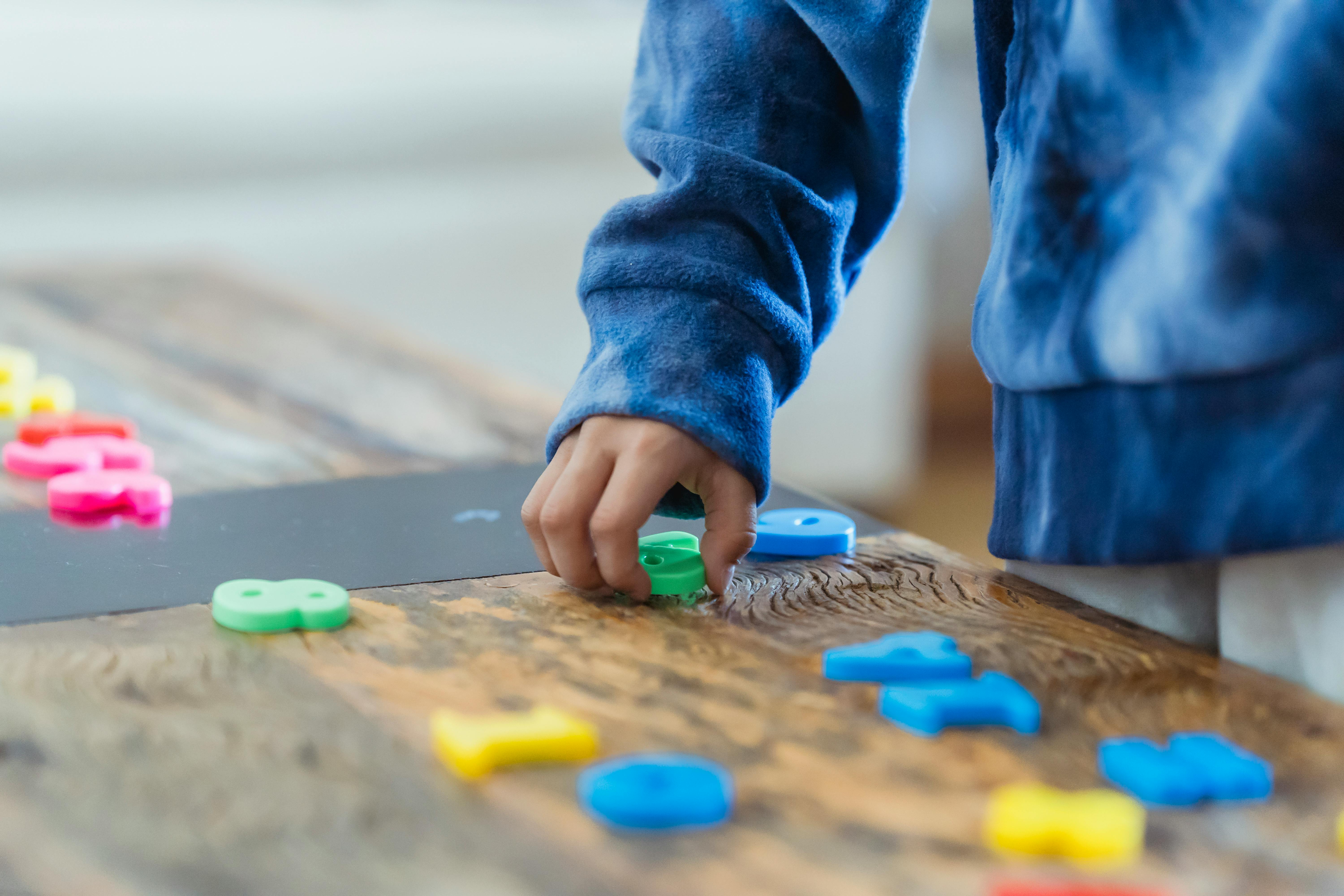 ethnic kid making row of toy numbers