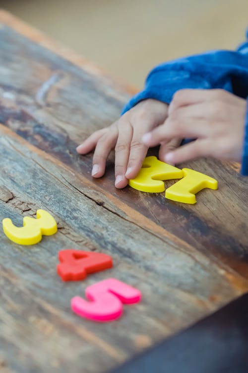 Free Little kid playing with plastic numbers Stock Photo