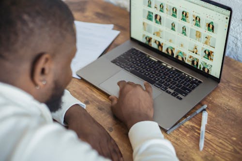 Black man surfing laptop during online work