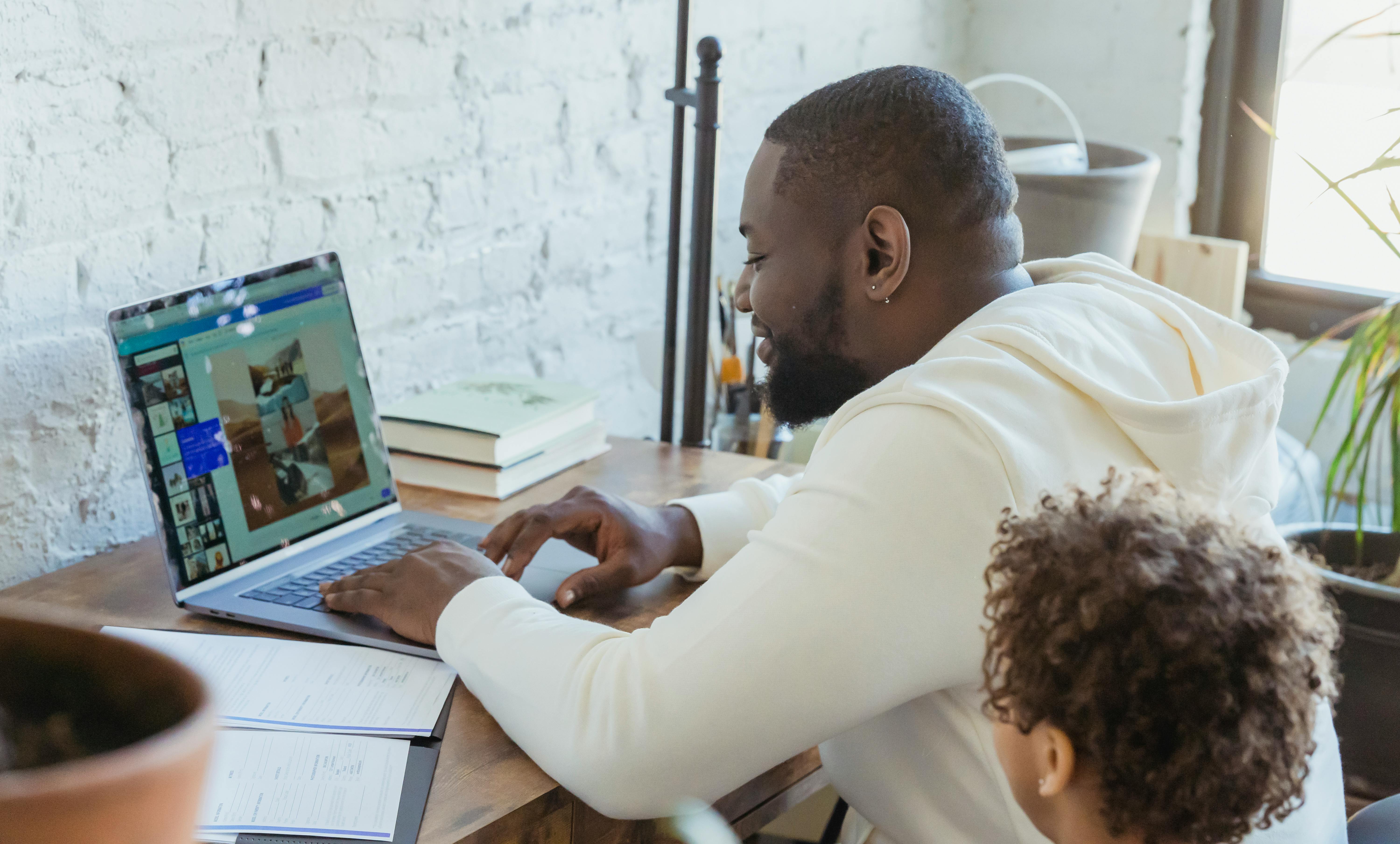 black father and boy browsing laptop in room