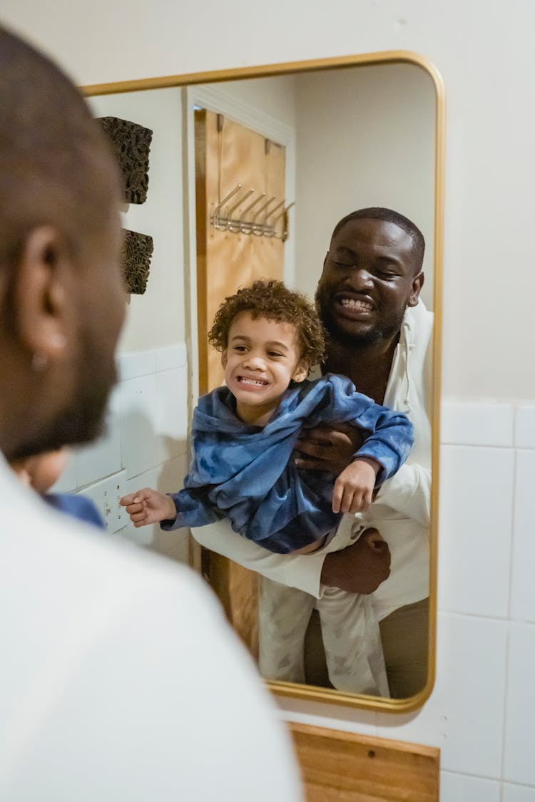 Black Father And Son In Bathroom With Mirror